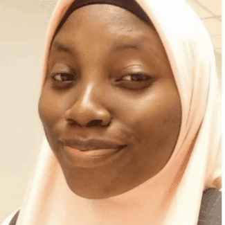 Anisat Ahmed smiling at the camera against a white background.